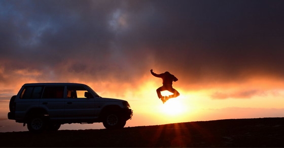 越野车与跳跃的人逆光摄影高清图片素材